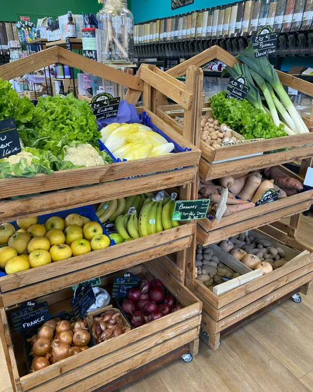 Cagettes en bois de fruits et légumes bio dans la boutique, devant le mur de silos